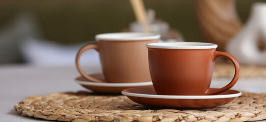 Cups of hot coffee on table in room, closeup