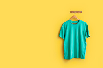 Stylish blue t-shirt hanging on yellow background