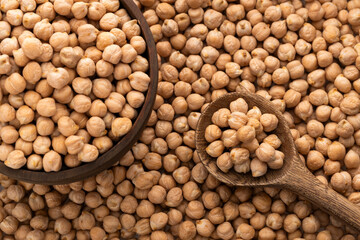 Organic raw dried chickpeas in the spoon and bowl - Cicer arietinum.