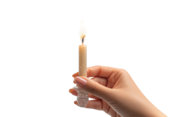 Female hand holding lit candle against black background, cut out