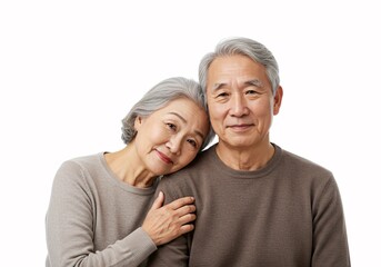 Senior couple happily hugging and embracing in casual light-colored shirts. Studio shot on a plain white background, showcasing their love and togetherness