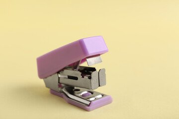 Lilac stapler on yellow background