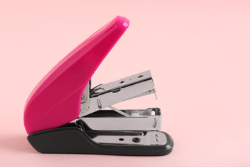 Pink stapler on color background