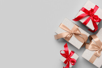 Gift boxes tied up with red and beige ribbons on grey background. Top view