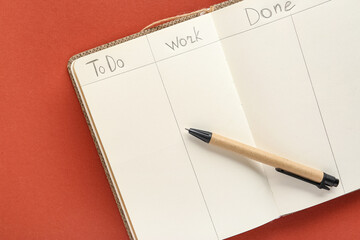 Open notebook with to do list and pen on brown background. Time management concept. Top view