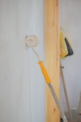 Painting a wall with a roller in a room renovation