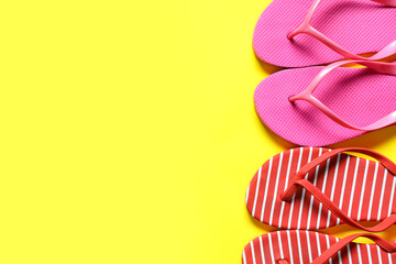 Different stylish flip-flops on yellow background