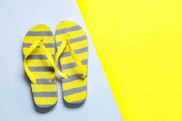 Stylish striped flip-flops on colorful background