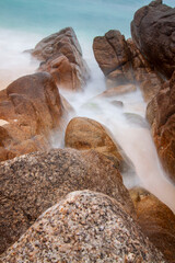 Rocky beach, sea water flows over rocks and stones