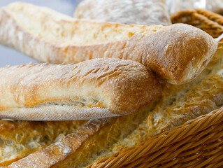 Freshly baked artisanal bread loaves arranged in a rustic basket ready for a satisfying meal or picnic