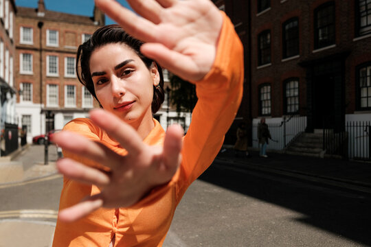 Young woman gesturing with hands in urban setting
