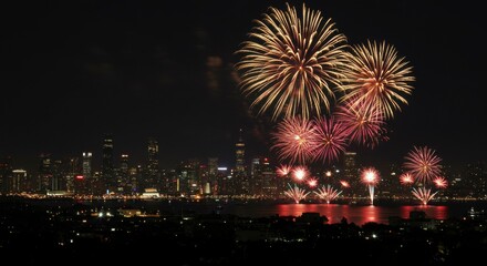 Vibrant fireworks illuminate a cityscape at night, reflected in the dark water