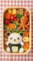 Bento box with bear-shaped rice, hot dog octopus, and flower carrots. Cute Japanese-style kids lunch