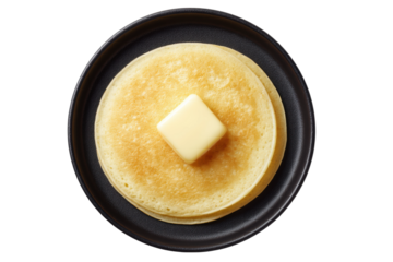 Golden pancakes with butter on black plate, cut out