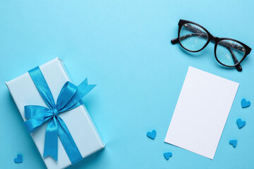 blue tie glasses and a gift box on a blue background