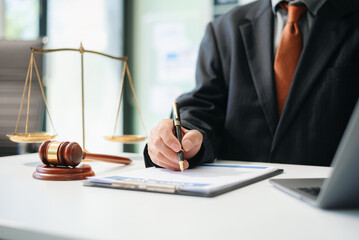 justice and law concept.Male judge in a courtroom  the gavel, working with tablet on table .