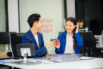 Fototapeta premium Two business workers talking on the smartphone and using laptop