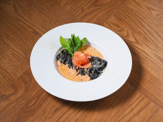 Squid Ink Pasta with Smoked Salmon and Cream Sauce on White Plate