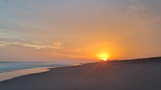 Golden Glow of Sunset on Black Sand Beach with Calm Ocean Waves, Orange Clouds Arranged Beautifully in Tropical Sky, Romantic and Peaceful Atmosphere Perfect for Relaxation Videos, Travel, Documentary