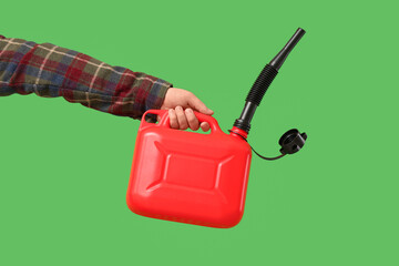 Male hand holding canister with rubber nozzle on green background