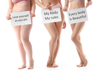 Young body positive women in underwear with slogans on white background