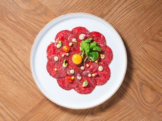 Beef Carpaccio with Raw Egg Yolk, Microgreens, and Gourmet Garnish