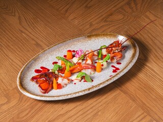 Gourmet Lobster with Vegetables and Red Sauce on Modern Ceramic Plate