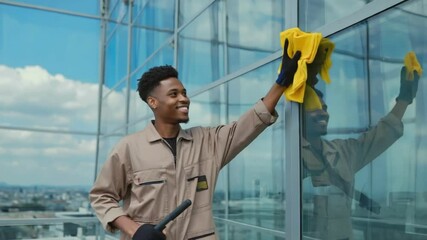 Window Cleaner at Work: A smiling window cleaner meticulously cleans a modern skyscraper's glass facade, showcasing his professionalism and dedication.