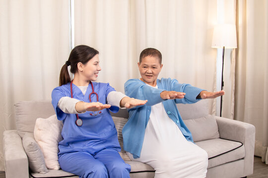 Senior patient doing arm stretching exercise with nurse in home setting, smiling and engaging in active elderly wellness session with support and care, healthcare, caregiver, take care, medical.