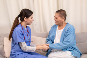 Obraz premium Young female nurse holding hands with senior woman, both smiling with trust and warmth during health support session in cozy home setting, healthcare, caregiver, take care, consult.