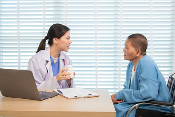 Obraz premium Female doctor consulting senior patient across table, pointing at laptop screen while discussing treatment plan in professional and friendly healthcare environment, illness, hospitality.