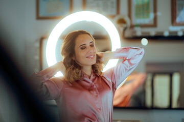 Woman Happy with New Look Poses in Front of a Ring Light. Lady styling her hair in loose curls...