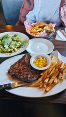 Hearty Steak Dinner with Salad, Fries, and Corn A Delicious and Satisfying Meal Experience