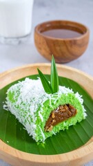 Sweet Klepon with Palm Sugar Filling and Grated Coconut on Banana Leaf with Pandan Garnish