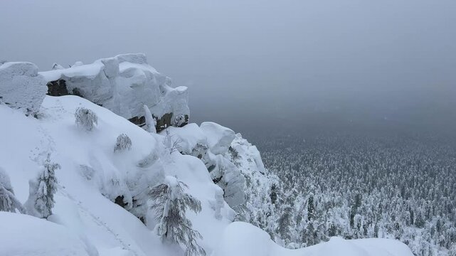 View of the white rocks and the winter forest on Mount Polyud. Lappish spruces on Mount Polyud in the Perm region in winter. In winter, there is a lot of snow and frost on the trees in the Urals. 4К