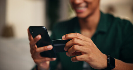 Credit card, phone and hands of man on sofa for online shopping, digital payment or fintech. Internet banking, account password and customer purchase with closeup of person in living room of home