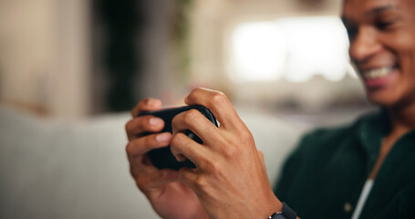 Gaming, phone and hands of man on sofa for esports streaming, cyber sport league and relax. Happiness, gamer app and subscription platform with person in living room of home for online tournament
