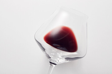 Red wine is inside stemware isolated on light gray.