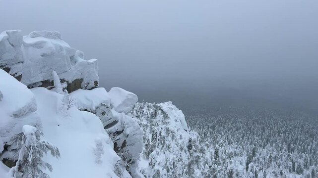 View of the white rocks and the winter forest on Mount Polyud. Lappish spruces on Mount Polyud in the Perm region in winter. In winter, there is a lot of snow and frost on the trees in the Urals. 4К