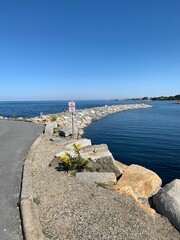 Fototapeta premium Scenic coastal view of Rockport, Massachusetts with clear blue water and distant shoreline