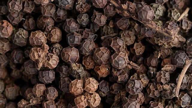 Organic black pepper kept on rotating disk. Macro video of black pepper.