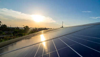 Solar panels capture sunlight over landscape at sunset, generating clean energy.