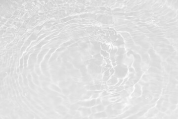 White water with ripples on the surface. Defocus blurred transparent white colored clear calm water surface texture with splashes and bubbles. Water waves with shining pattern texture background.