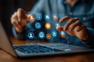 Person interacting with a futuristic holographic digital interface projecting various icons above a laptop keyboard in a dimly lit environment