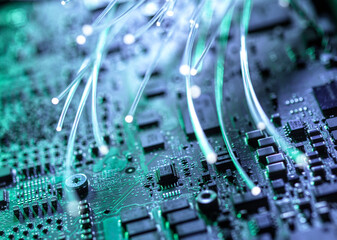 Close-up of a circuit board with glowing fibre optics representing data and innovation in technology