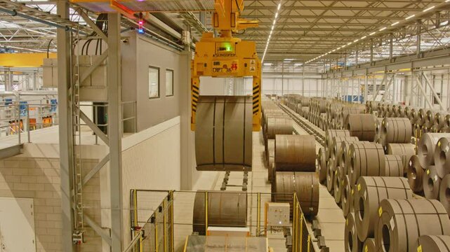 Tilt down of a clamp placing a heavy steel coil on a transportation system