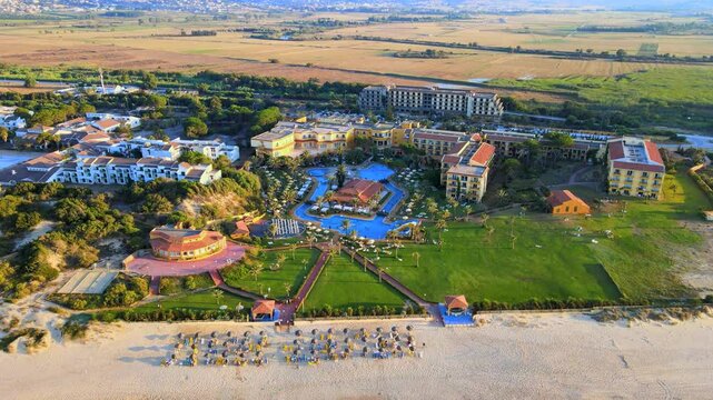 Looking down on beach chairs and hotels, with a hotel overlooking the beach.