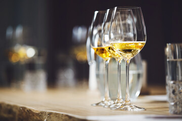 White wines in glasses on table, sommelier tasting preparation. White wines in glasses on table, sommelier tasting preparation. Wine waiter training, winemaking school.