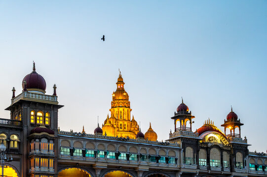 Mysore Palace in Karnataka, India, with a bird flying in the evening sky