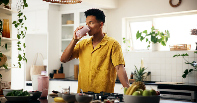 Man, drinking and smoothie in kitchen for detox, healthy diet and meal replacement for wellness. Nutritionist, enjoy and protein shake in home for gut health, vitamin boost and supplement with fruit